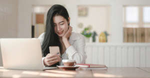 スマートフォンを見ながらスペシャリティコーヒーを飲む女性